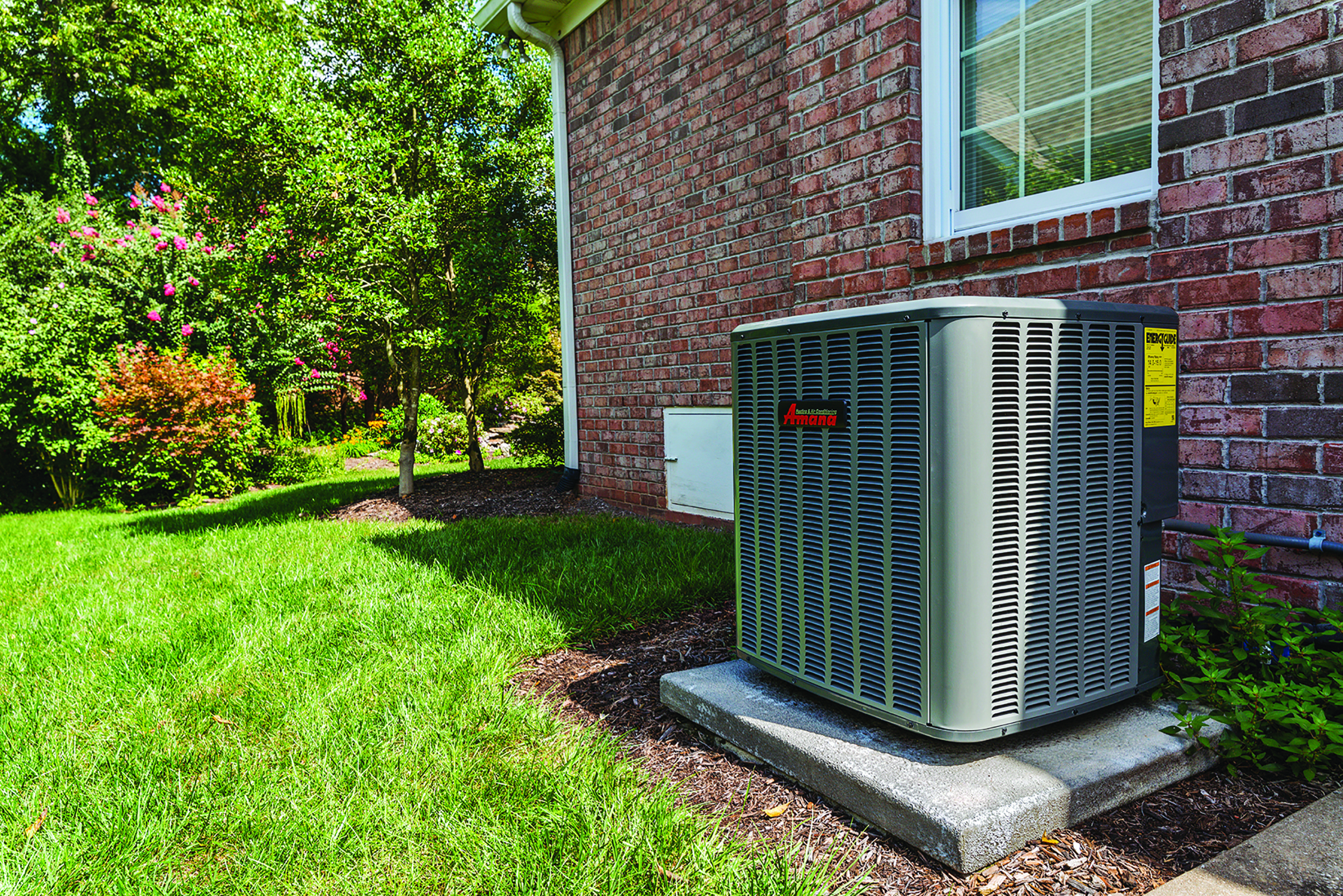 Amana air conditioning condenser unit installed outside a brick home in Elgin, IL